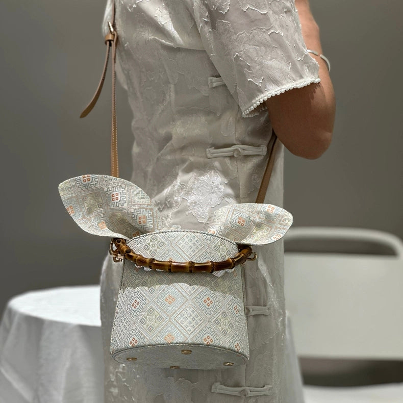 Handmade Zhuang Brocade Bucket Bag with Bamboo Handle | Artisan Crafted Ethnic Crossbody Bag with Bunny-Ear Brocade Flap