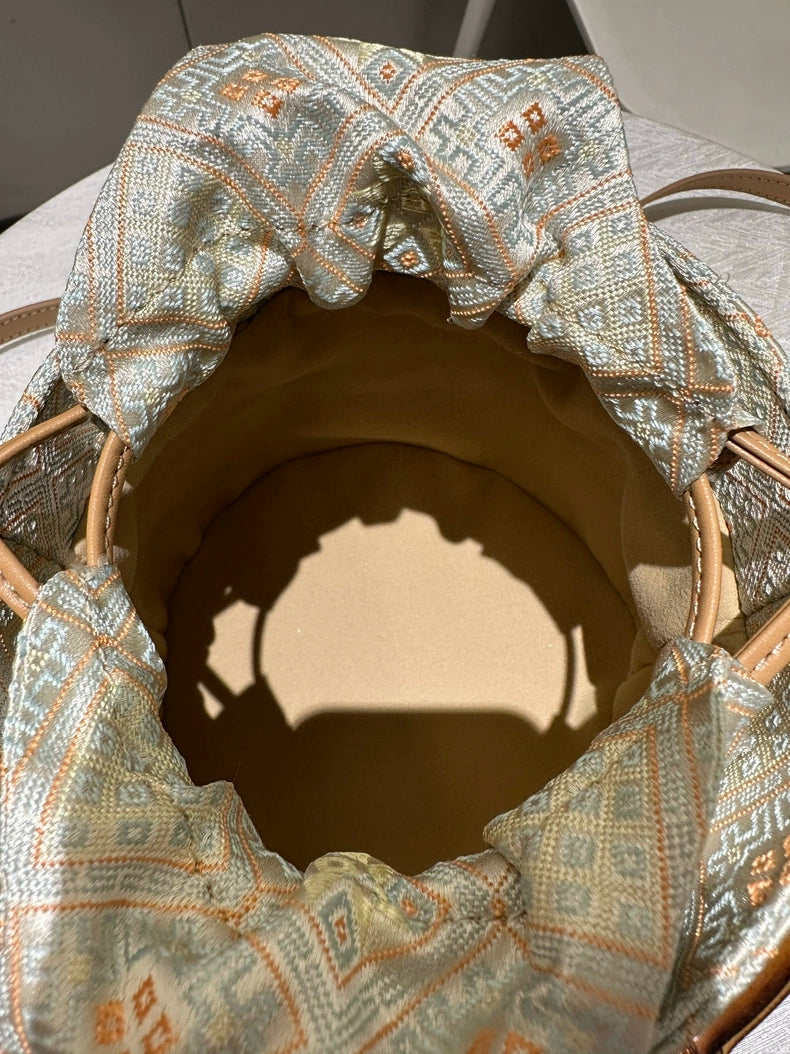 Handmade Zhuang Brocade Bucket Bag with Bamboo Handle | Artisan Crafted Ethnic Crossbody Bag with Bunny-Ear Brocade Flap