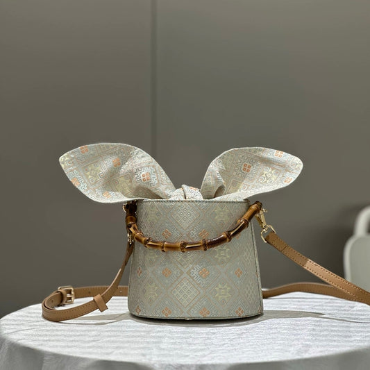 Handmade Zhuang Brocade Bucket Bag with Bamboo Handle | Artisan Crafted Ethnic Crossbody Bag with Bunny-Ear Brocade Flap