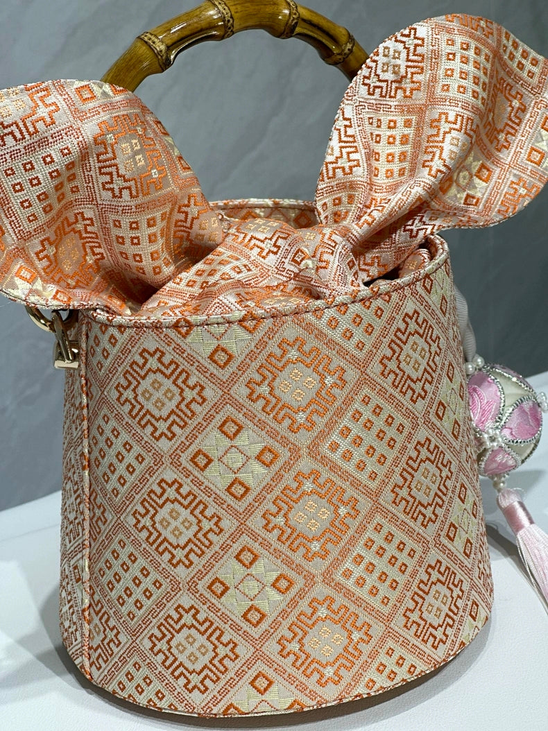 Handmade Zhuang Brocade Bucket Bag with Bamboo Handle | Artisan Crafted Ethnic Crossbody Bag with Pink Tassel Charm