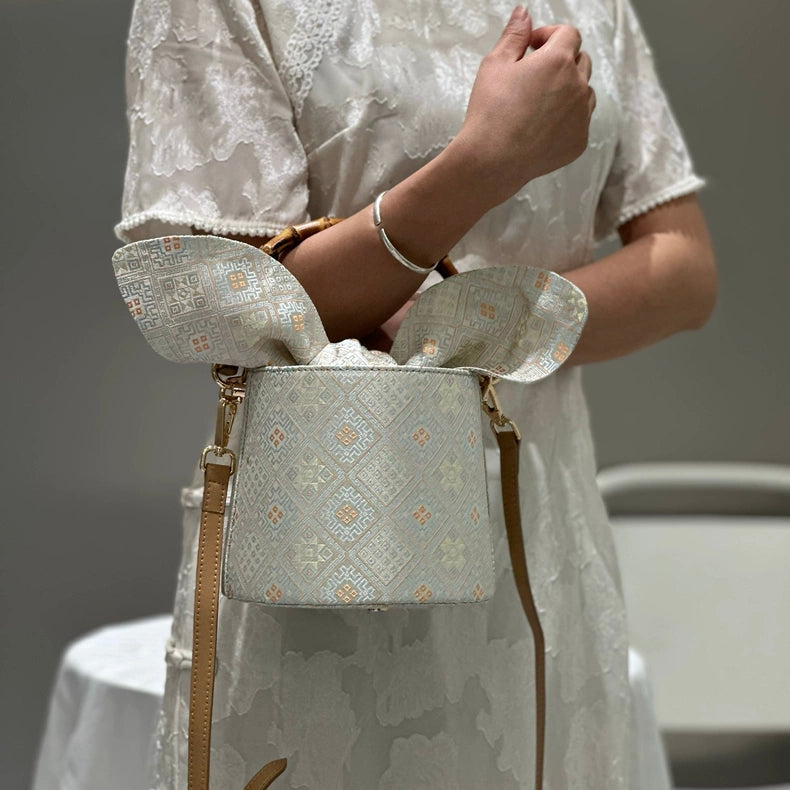 Handmade Zhuang Brocade Bucket Bag with Bamboo Handle | Artisan Crafted Ethnic Crossbody Bag with Bunny-Ear Brocade Flap