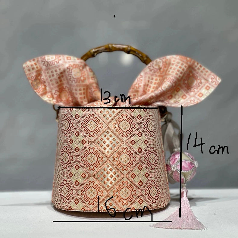 Handmade Zhuang Brocade Bucket Bag with Bamboo Handle | Artisan Crafted Ethnic Crossbody Bag with Pink Tassel Charm